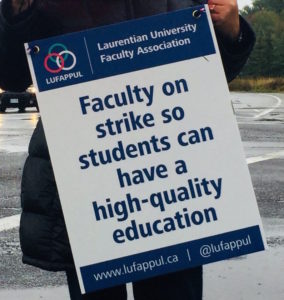 Laurentian strike poster being held up by faculty